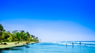 A serene beach scene with people enjoying water activities.