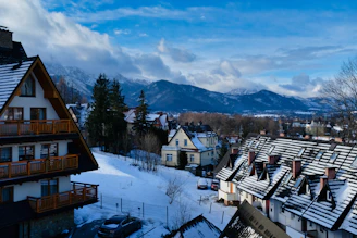 brown and white wooden houses on snow covered ground near mountains during daytime