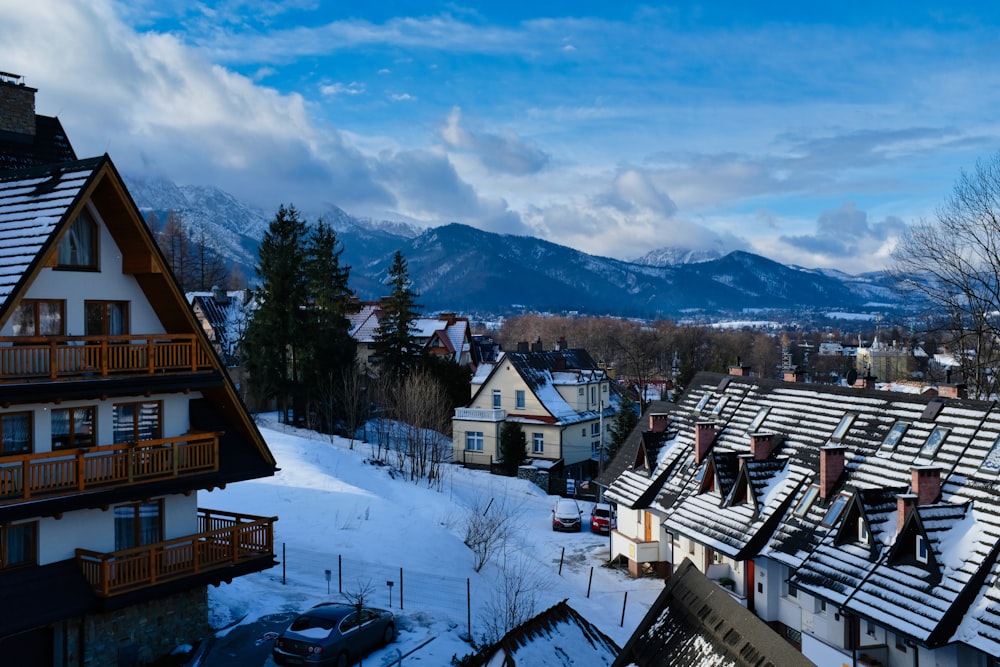 brown and white wooden houses on snow covered ground near mountains during daytime