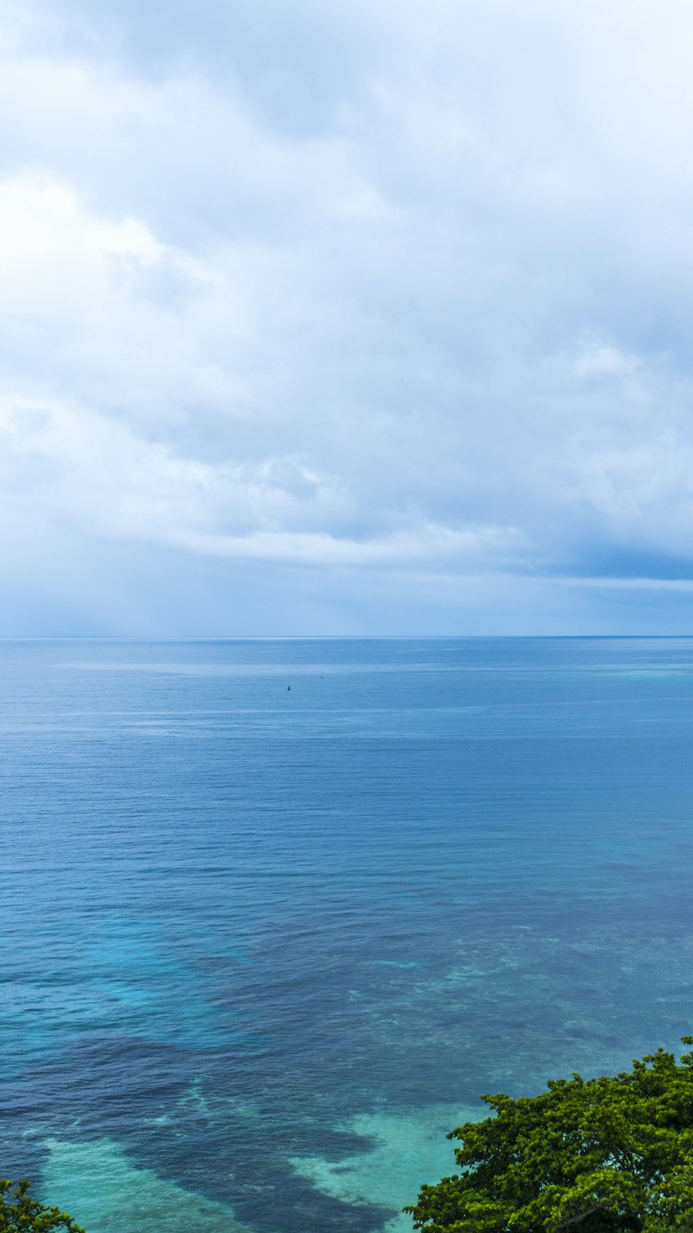 mar azul sob nuvens brancas durante o dia