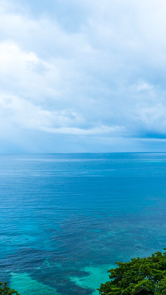 blue sea under white clouds during daytime in Ocho Rios Jamaica
