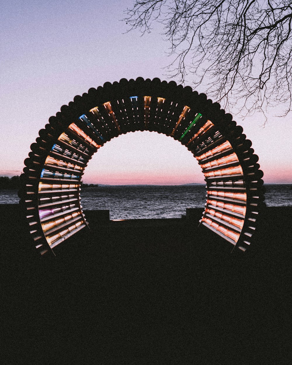 brown wooden arch near body of water during daytime