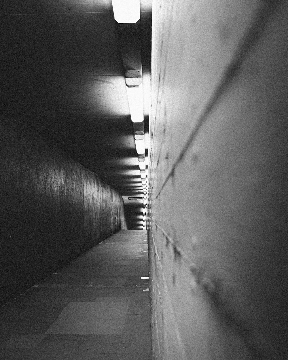 grayscale photo of tunnel with light