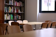 A quiet study room filled with stacks of books and notes related to monastic precepts.