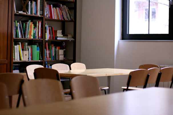 A bright, inviting research room with bookshelves and a large window letting in natural light.