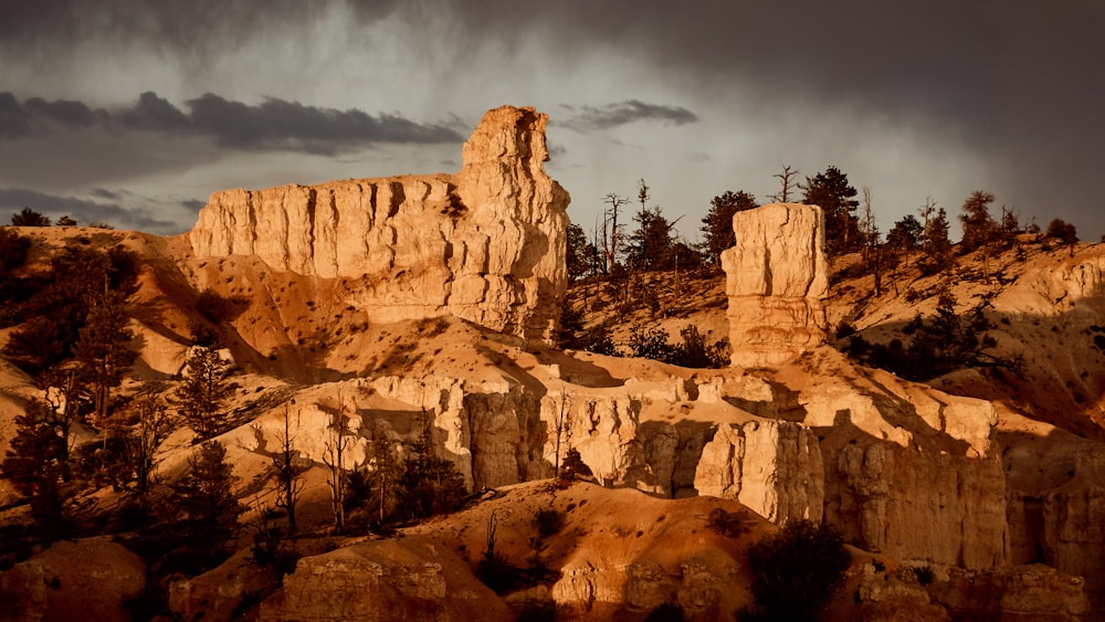 brown rock formation under gray clouds