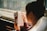A person is reading a book while sitting next to a window. The book cover displays the title 'The Girl Who Played with Fire' by Stieg Larsson. The surroundings outside the window appear to be blurred.