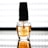 A clear bottle of OPI top coat nail polish stands on a reflective surface. The label on the bottle is visible with black text, and there is a dark-colored cap on top. The background is bright and evenly lit, enhancing the visibility of the product.