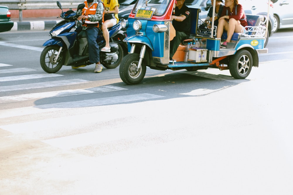 people riding on blue and black motorcycle during daytime