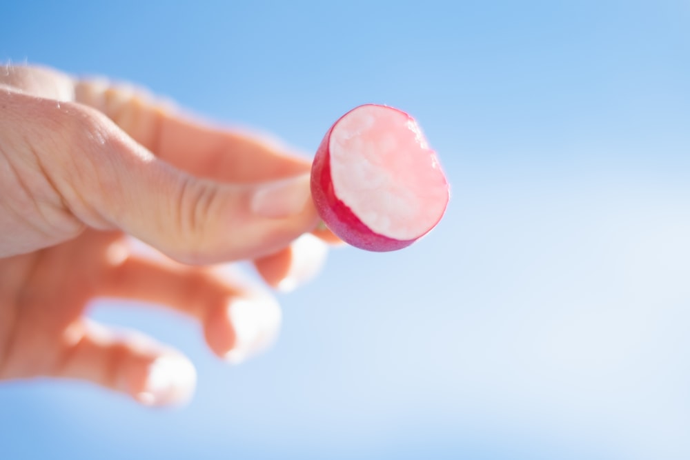 person holding pink heart ornament