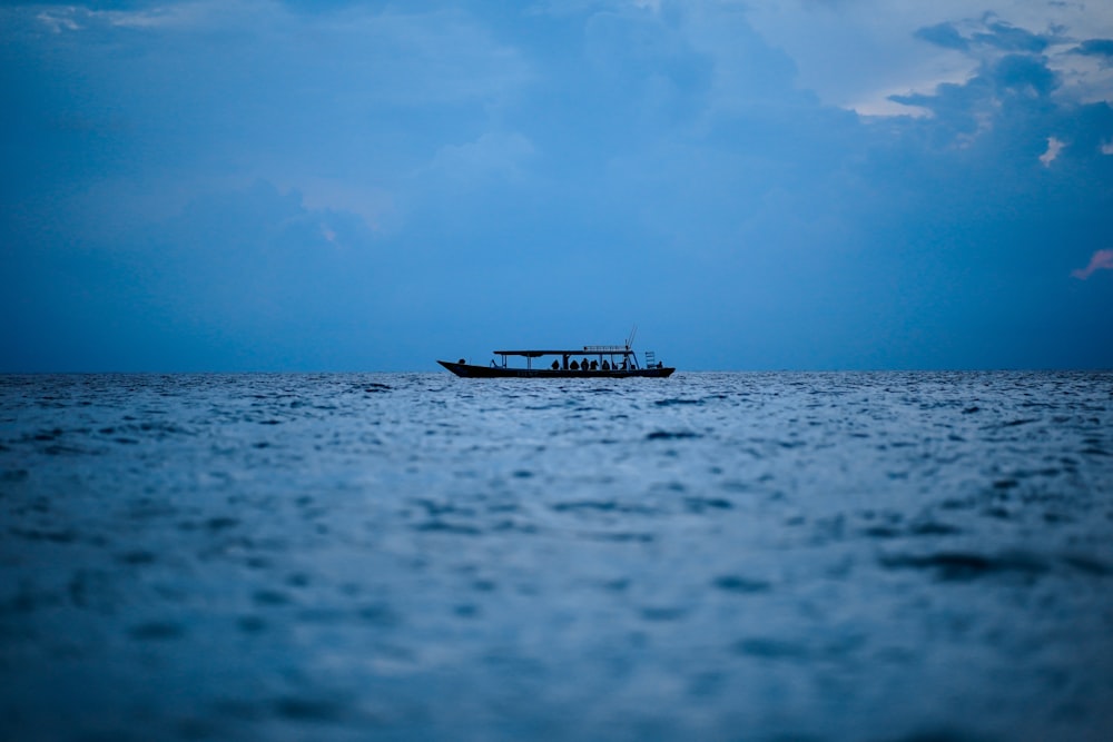 昼間の青空の下、海上に浮かぶ白いボート