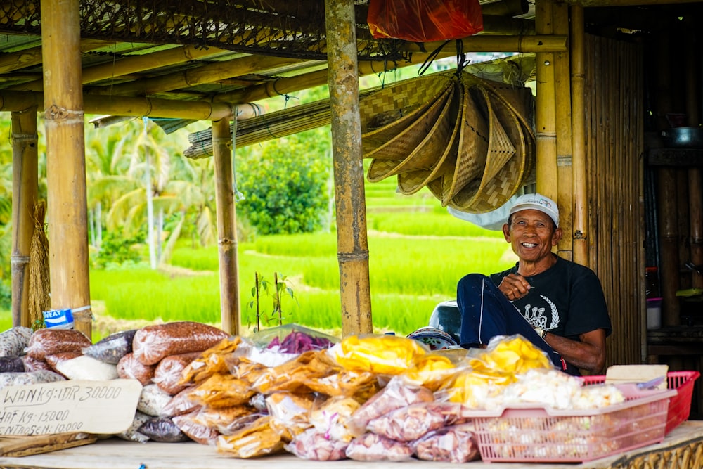 man in black shirt sitting beside food