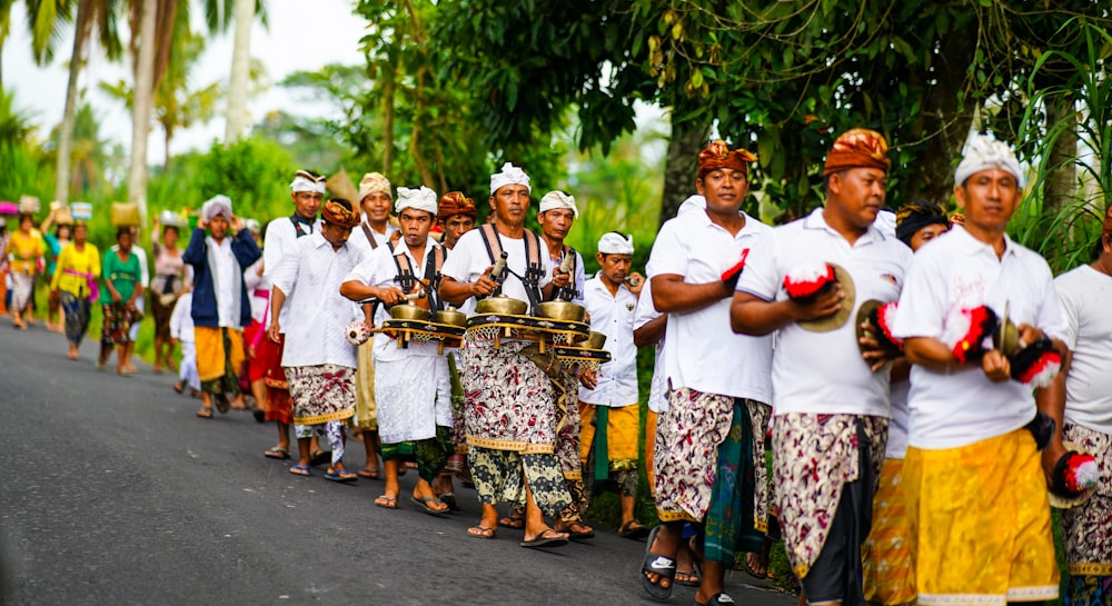 group of women standing on gray asphalt road during daytime