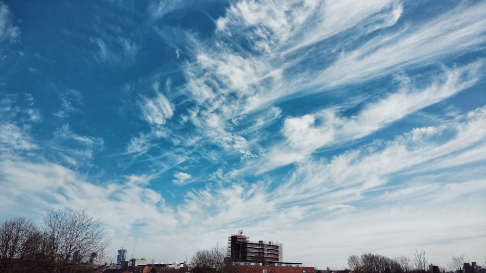 brown concrete building under blue sky and white clouds during daytime