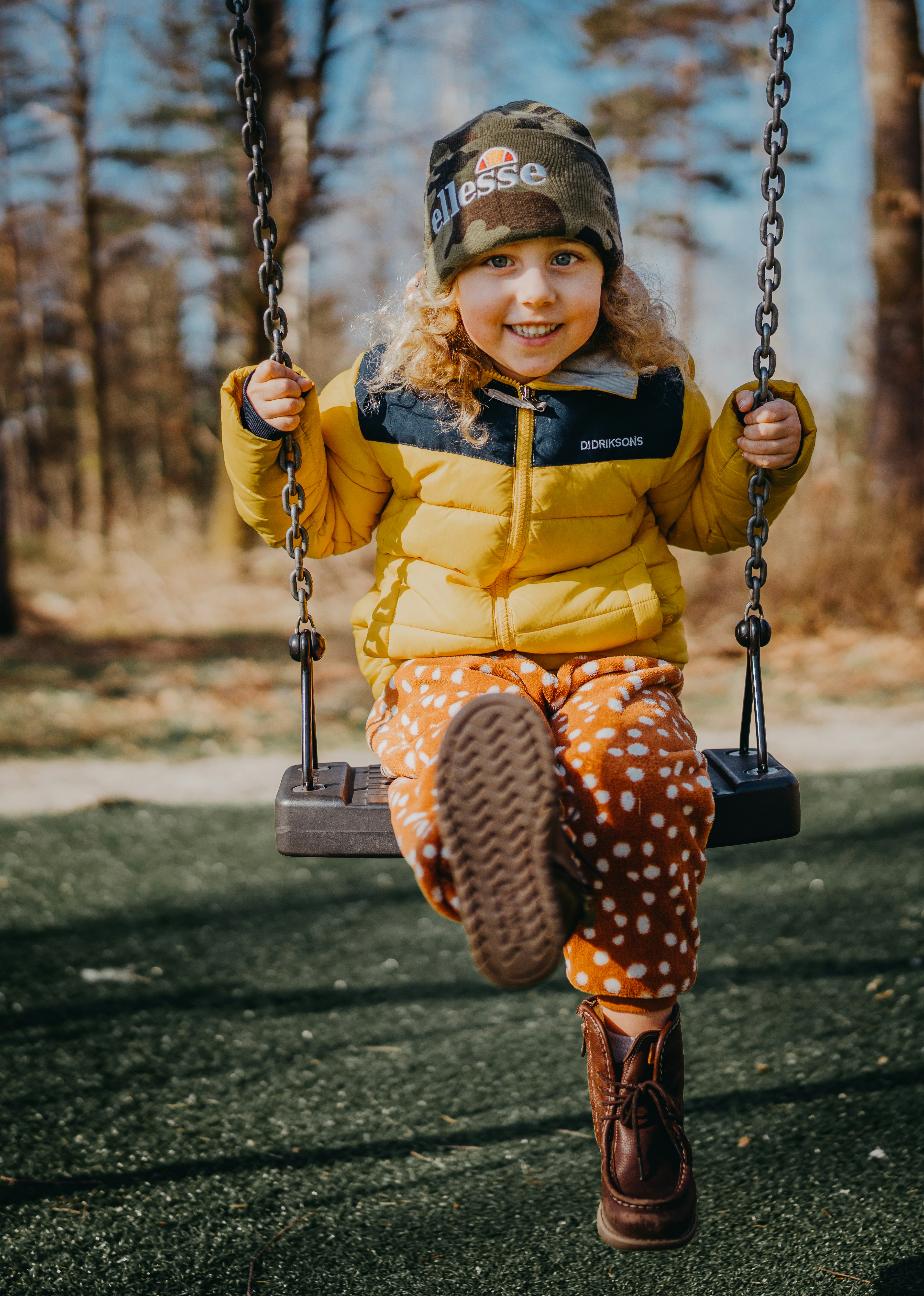girl in yellow and black dress sitting on swing during daytime
