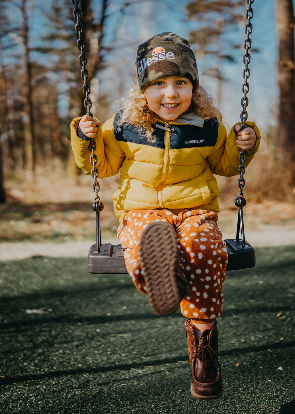 girl in yellow and black dress sitting on swing during daytime