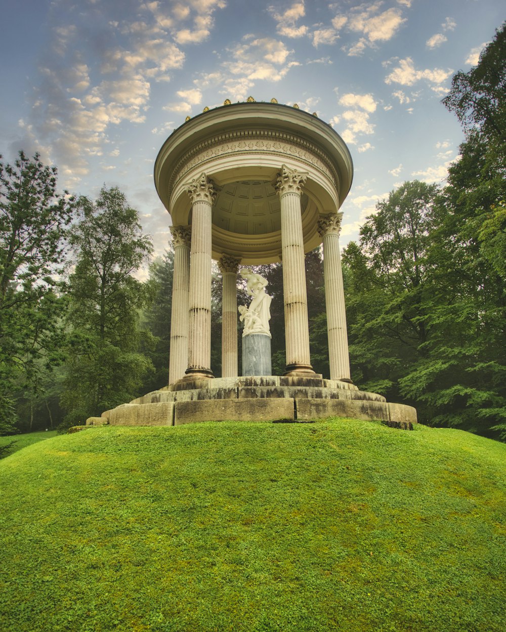 white concrete statue on green grass field during daytime