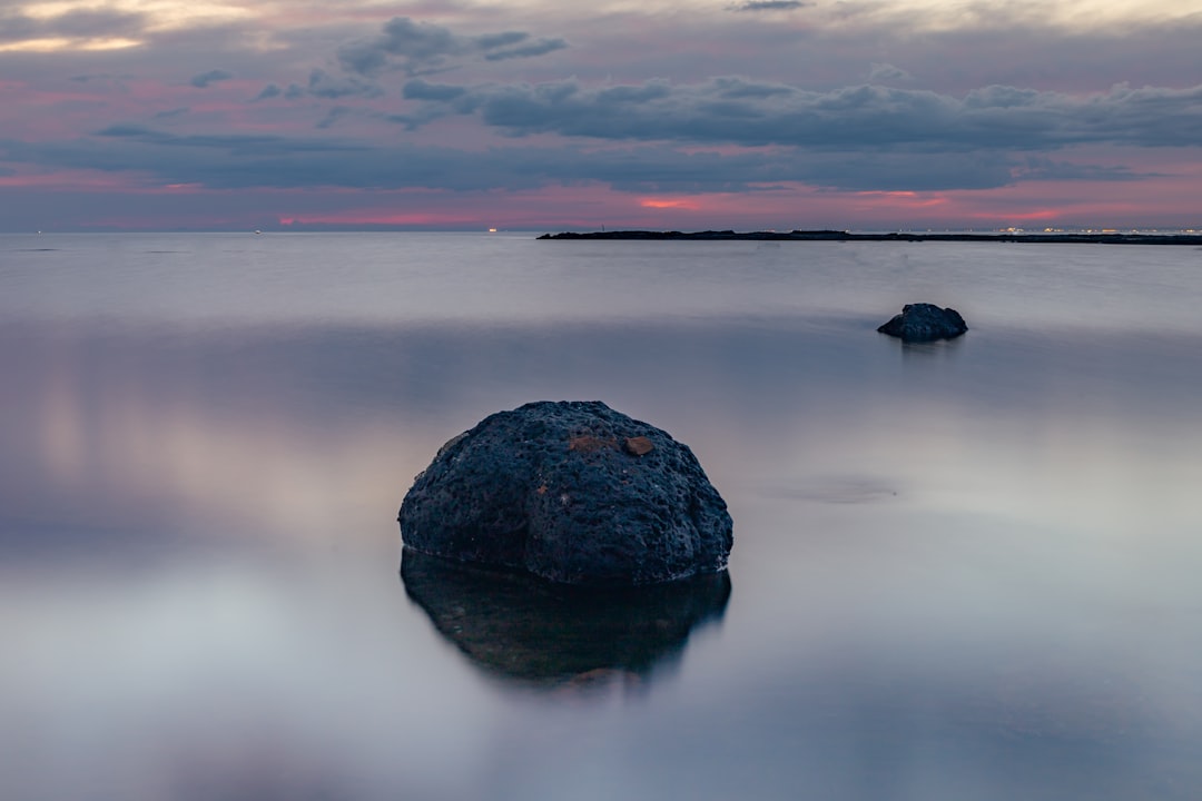 black rock on body of water during daytime