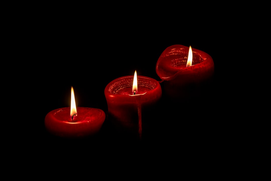 red pillar candles on black surface