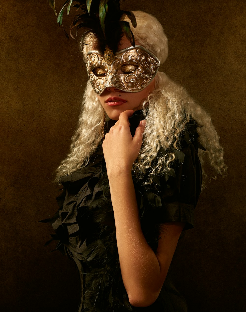mujer con vestido blanco y negro con máscara dorada
