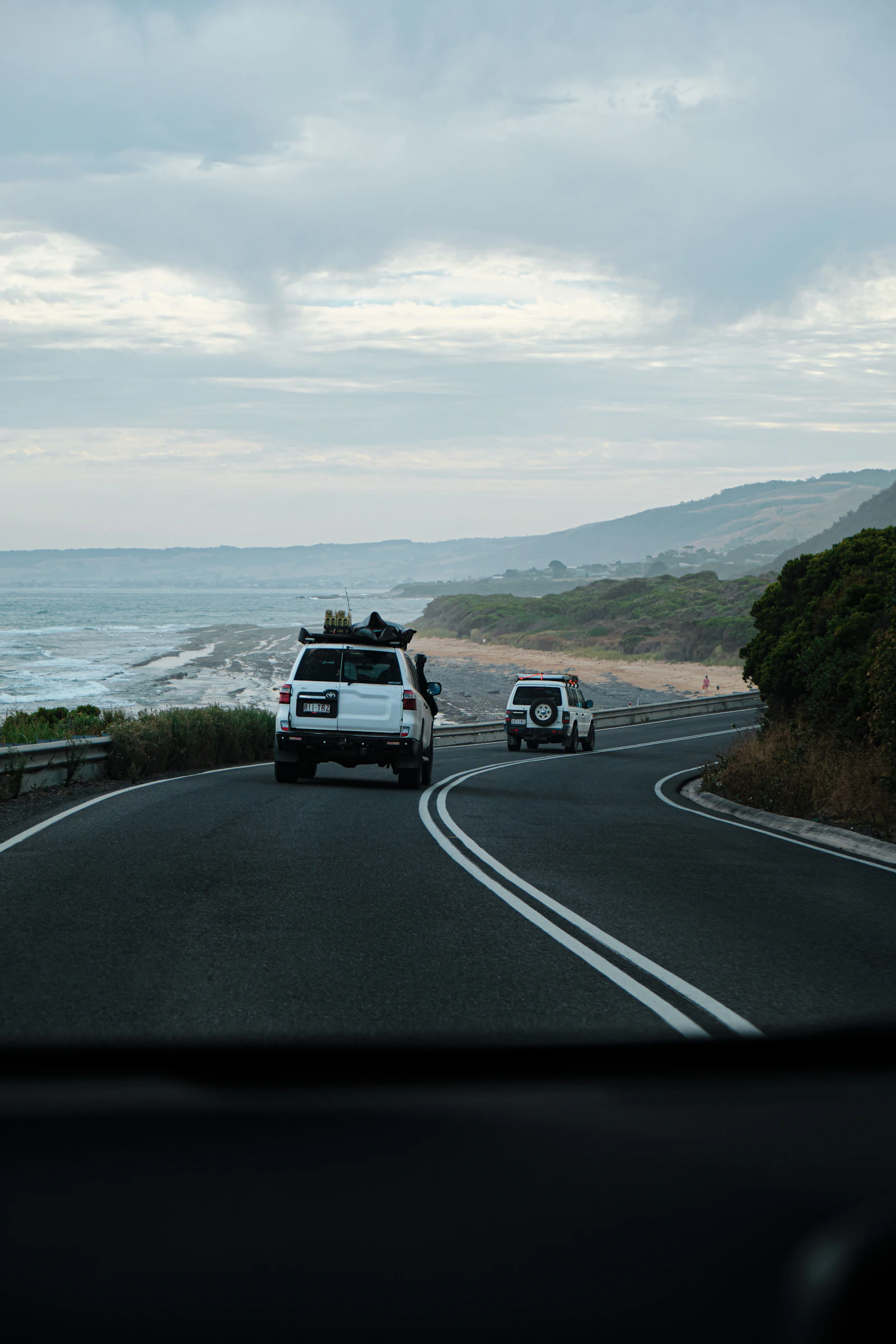 A white SUV stopped beside the coast on the Great Ocean Road