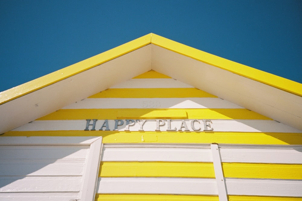 maison en bois jaune et blanc sous le ciel bleu pendant la journée