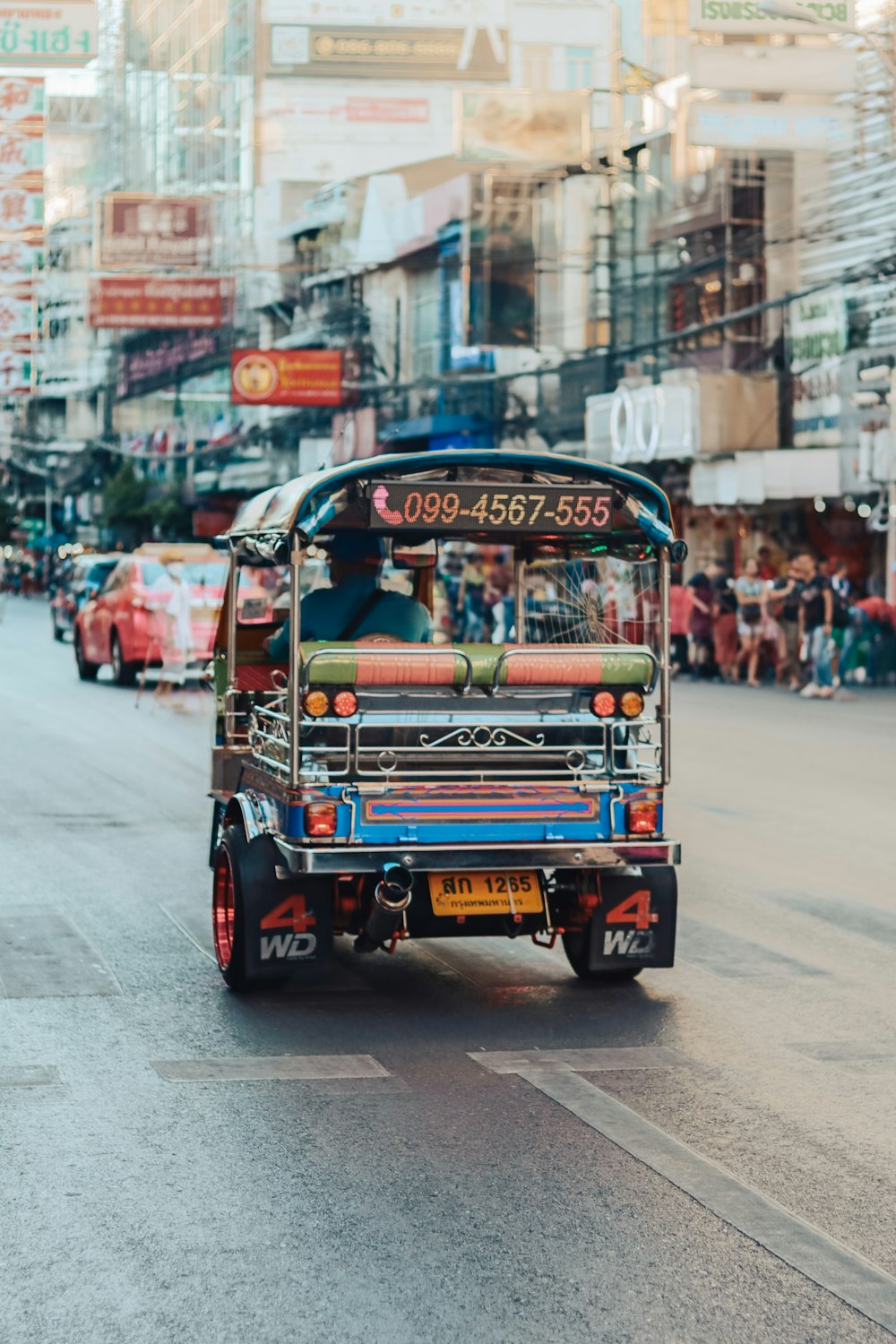 rickshaw rojo y azul en la carretera durante el día