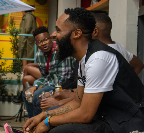 man in white t-shirt sitting beside man in black t-shirt
