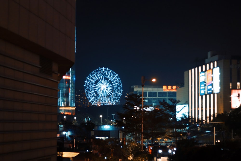 Grande roue près d’un immeuble de grande hauteur pendant la nuit