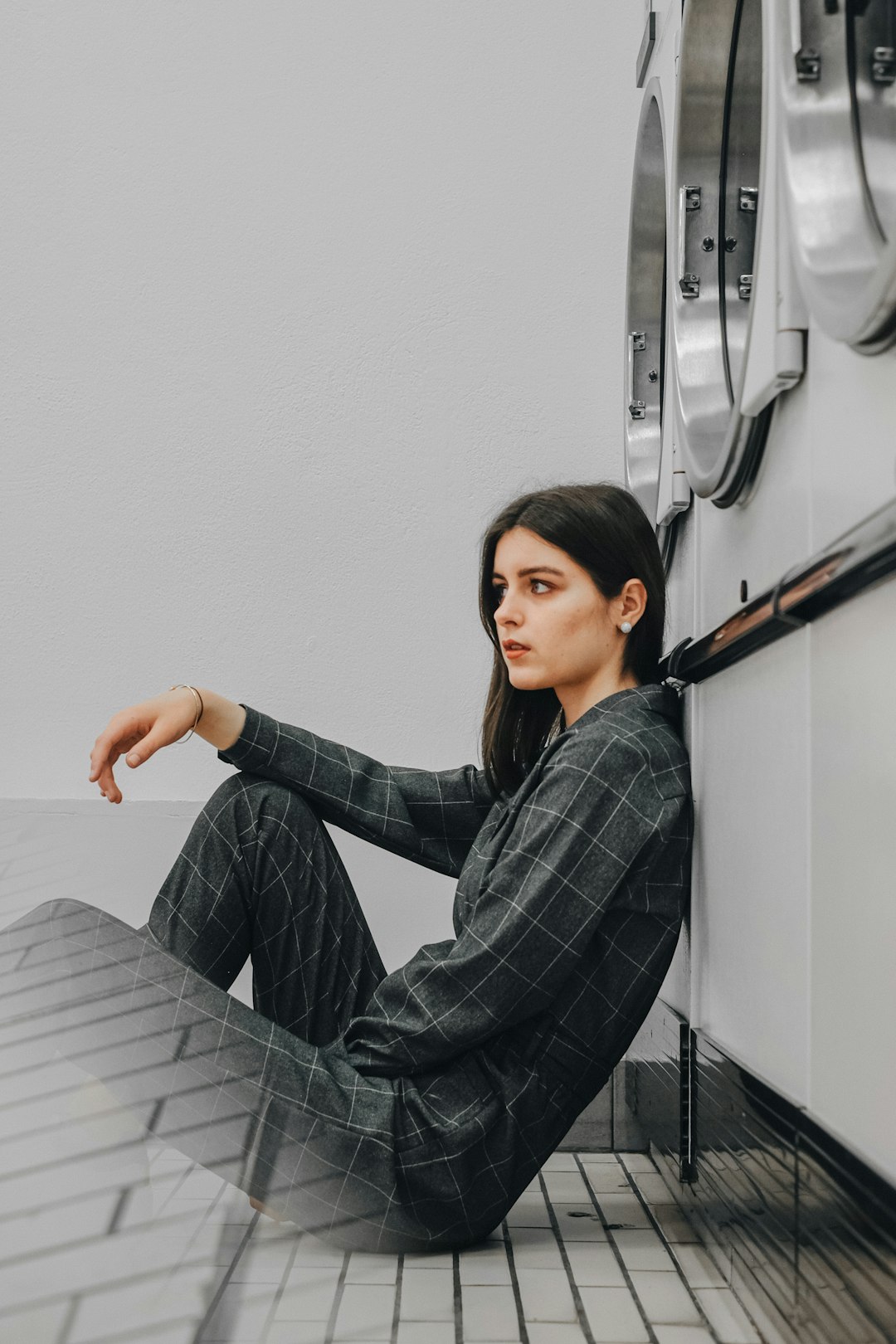 woman in blue and white plaid dress shirt sitting on white bed