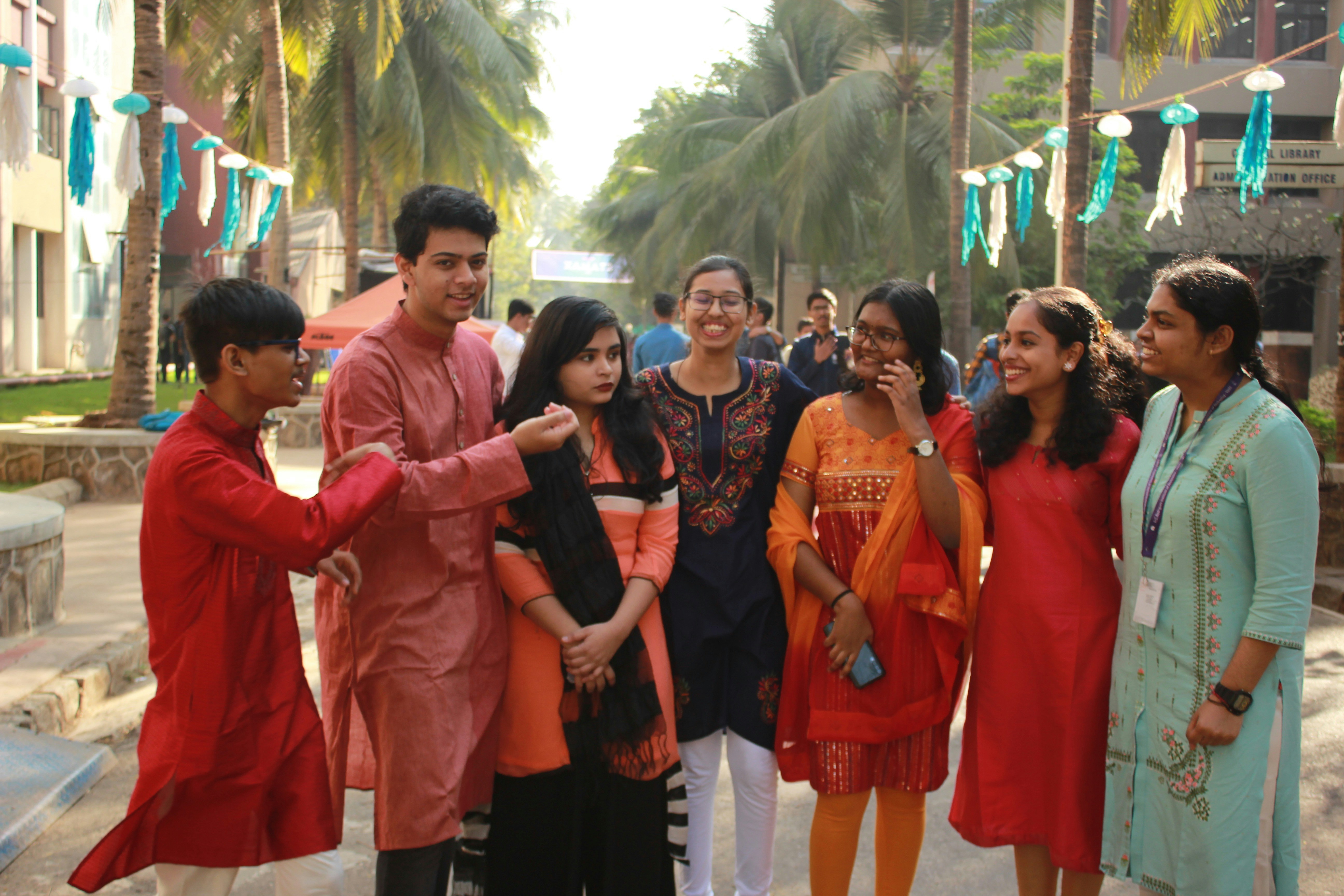 Group of diverse community members smiling together outdoors in a village setting, warm natural light