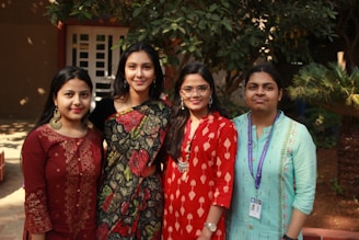 3 women standing near green plant