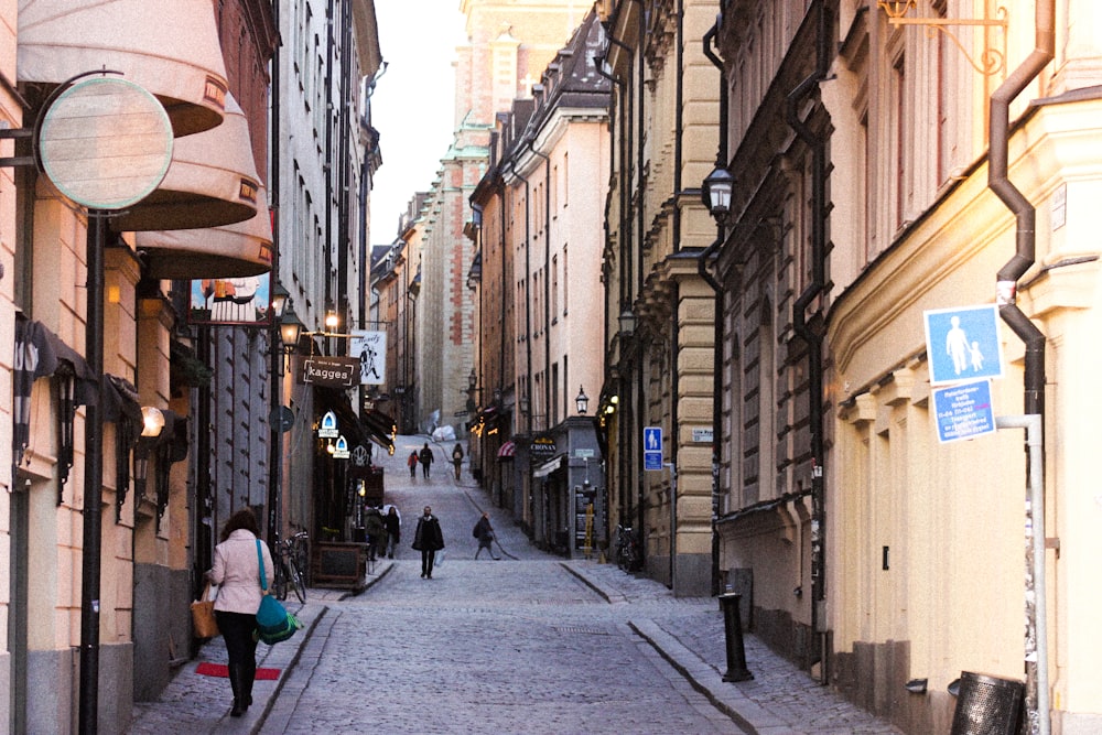 people walking on street between buildings during daytime