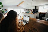 woman in brown sweater using macbook pro