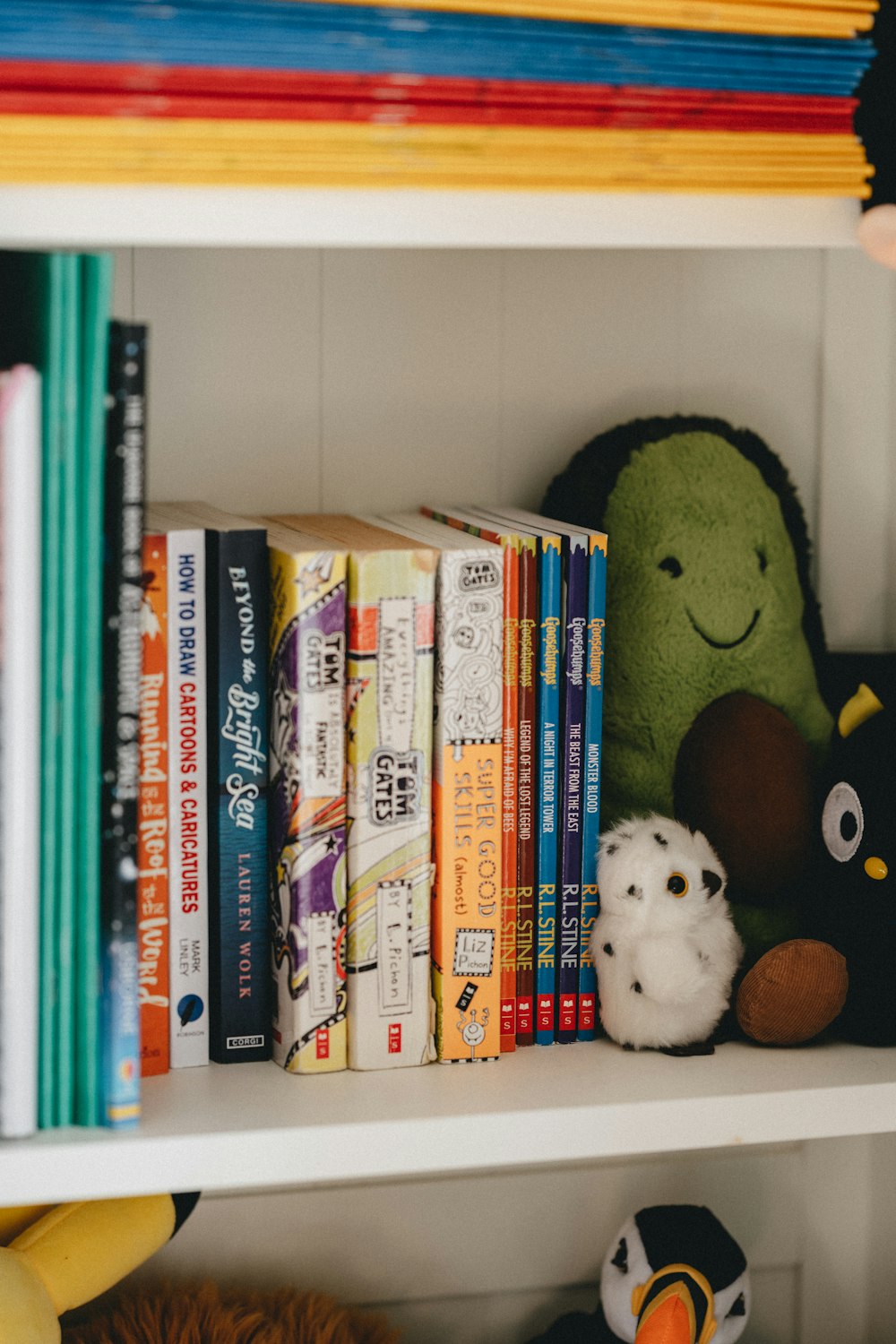 white and brown dog plush toy on books