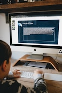 silver imac on brown wooden desk