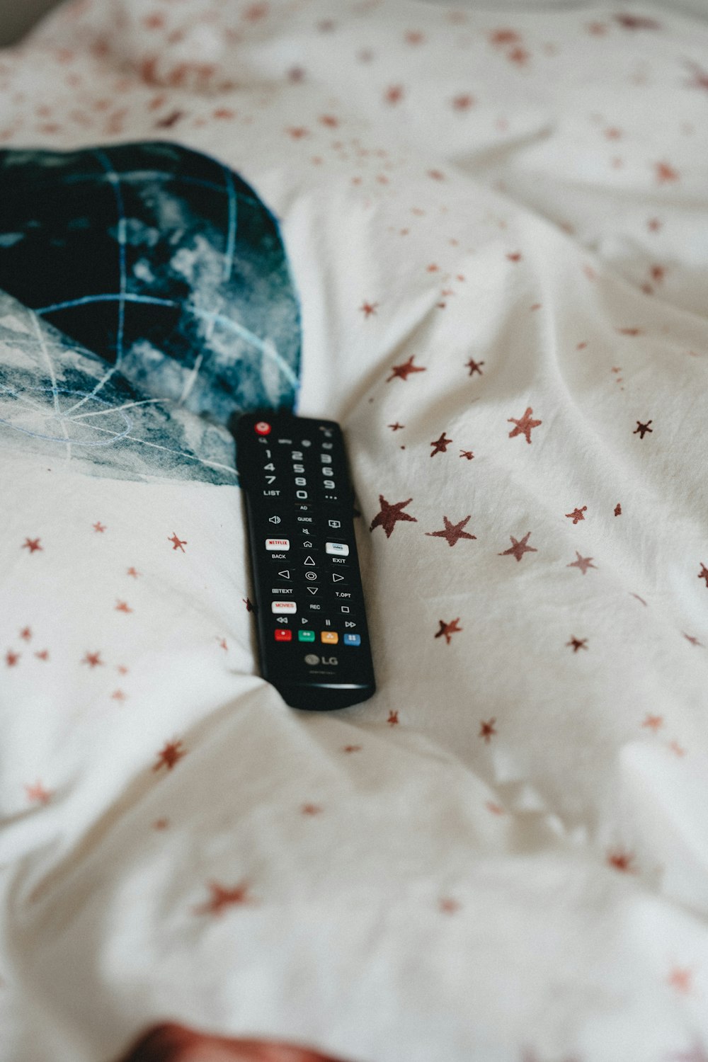 black remote control on white and red textile