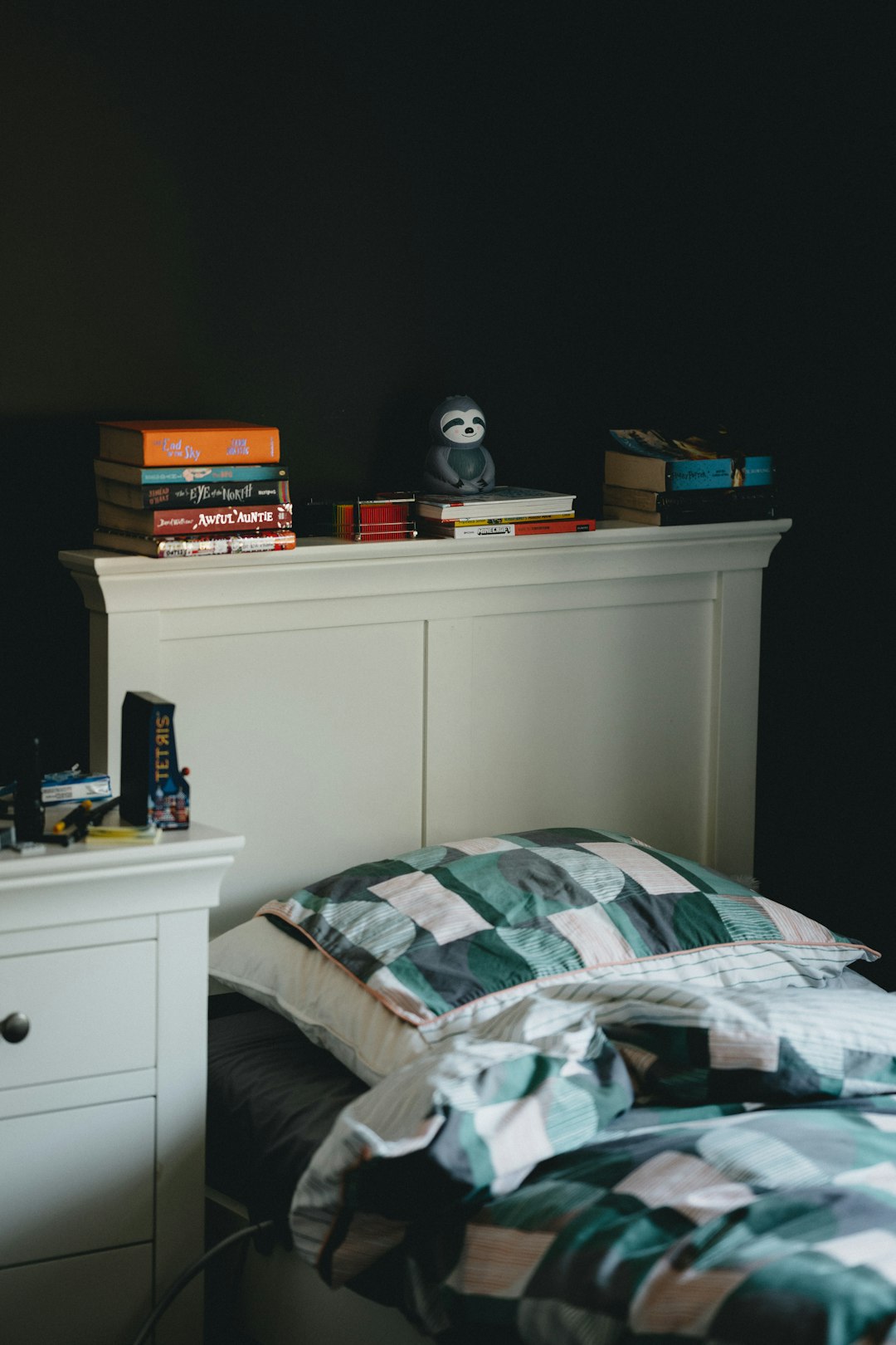 white wooden drawer beside white wooden bed frame