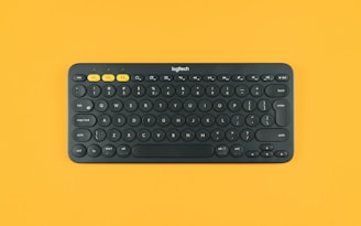 black logitech keyboard on orange surface