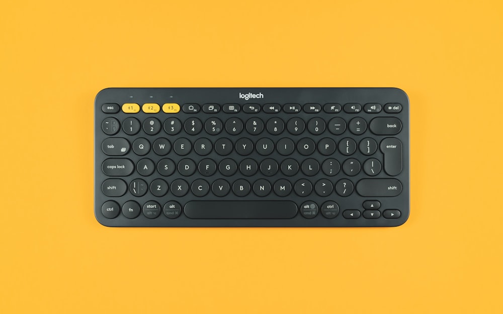 teclado logitech preto na superfície laranja