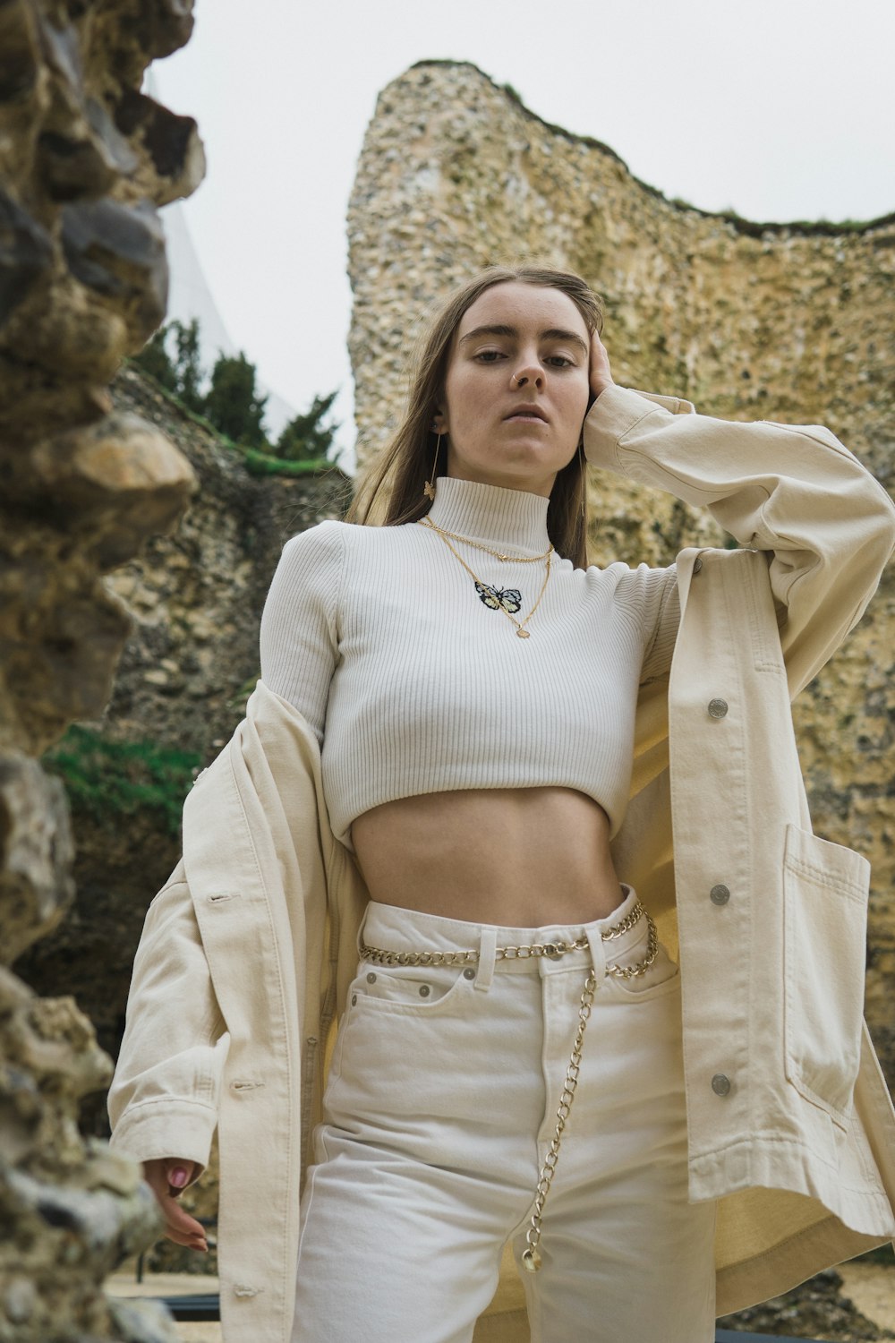 a woman in a crop top and white pants