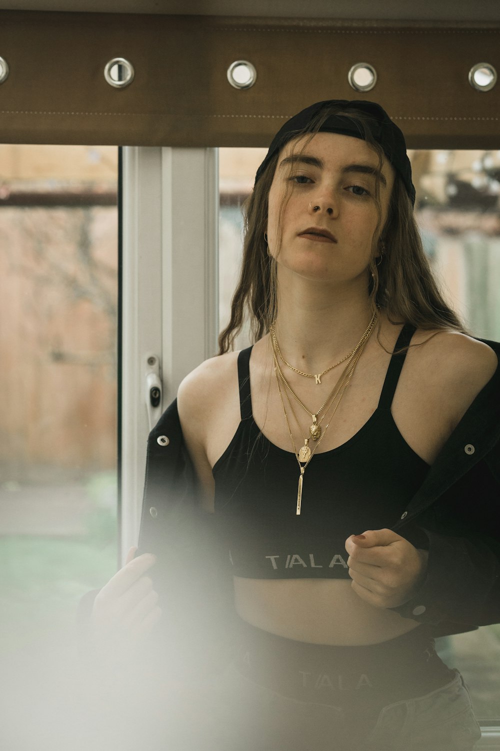 woman in black tank top wearing gold necklace