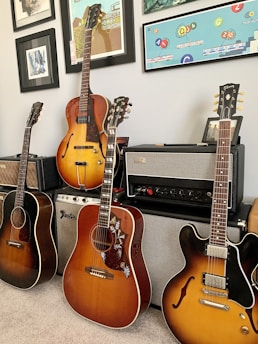 A cozy music room with several guitars hanging on the wall, showcasing various styles.