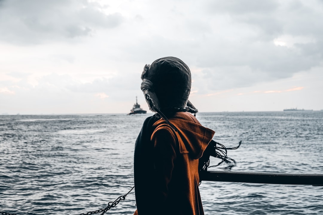 woman in orange jacket standing on boat during daytime