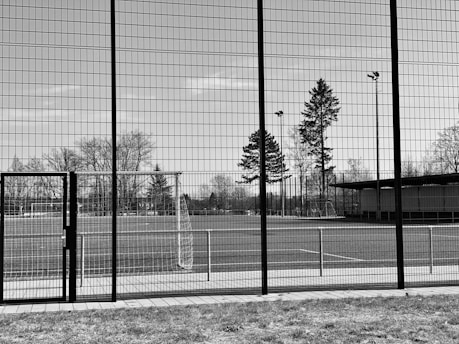 Image of a large vibrant sports banner displayed on a fence at a youth baseball field.