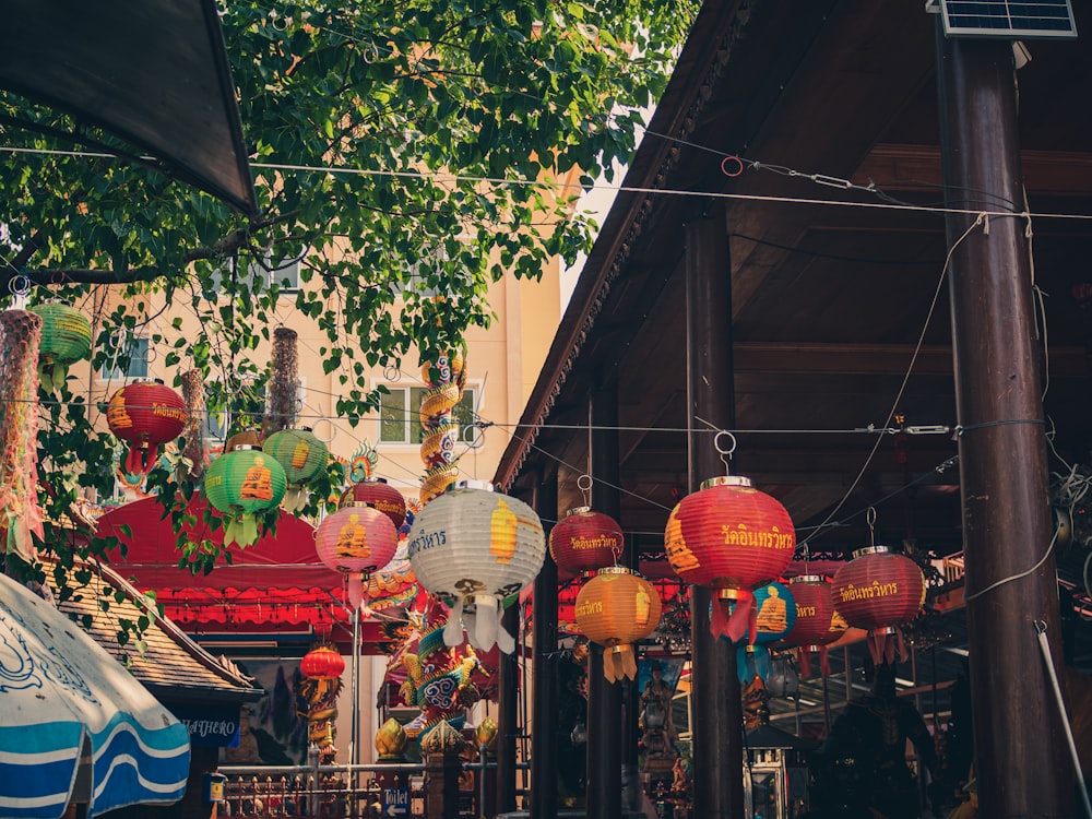 red and yellow paper lanterns hanged on brown wooden post