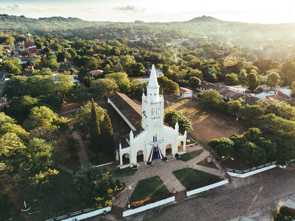 white and black church surrounded by green trees during daytime