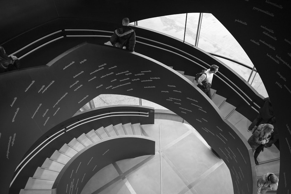 man in black jacket walking on spiral staircase