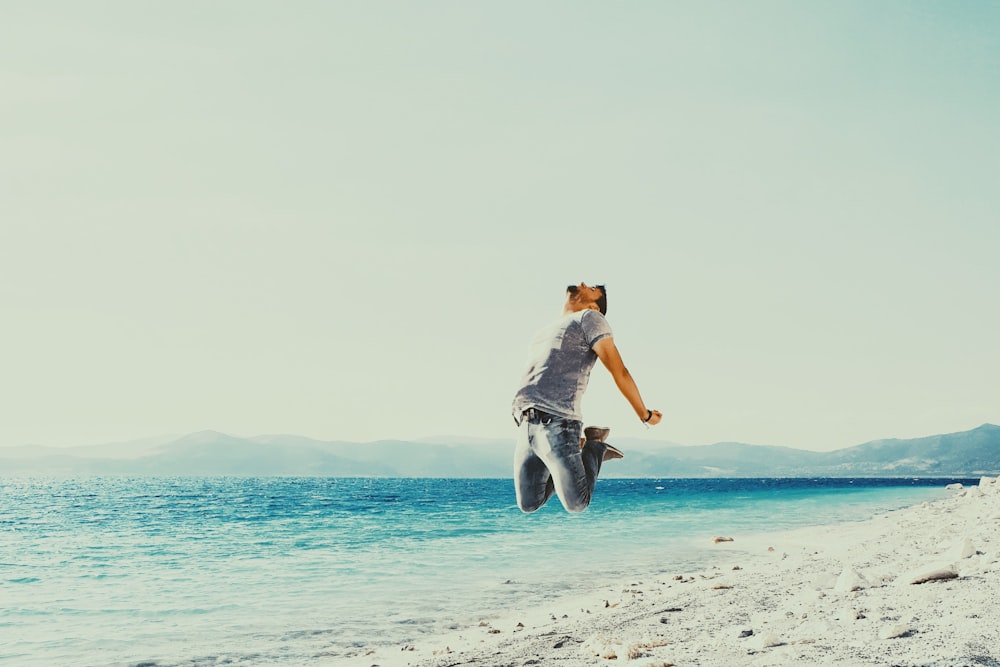 Femme en veste en jean bleu et jean en jean bleu debout sur la plage pendant la journée