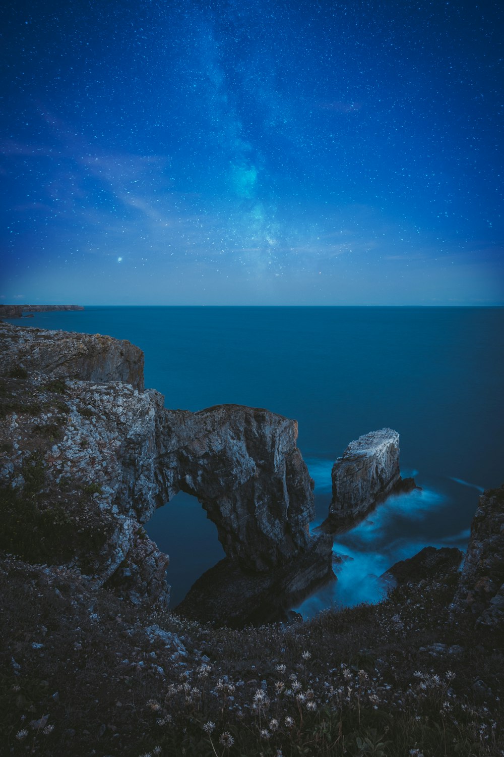 brown rock formation on sea under blue sky during daytime